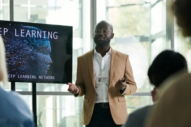 Young black man in formal wear standing by interactive board during presentation